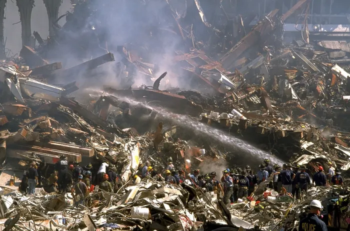 Framed Print : Firemen sprays still burning ruins of the World Trade Center on Sept 16, 2001. In upper right are ruins of WTC 3, the Marriott World Trade Center, once a 22 story hotel