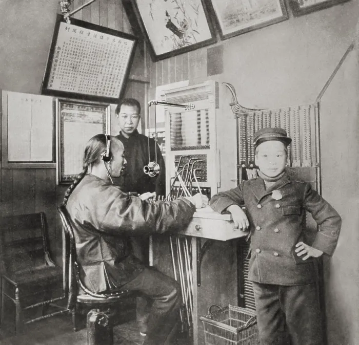 Framed Print : The first Chinese telephone operator in Chinatown, San Francisco, with a messenger boy standing by, 1910-1930 (BSLOC_2018_1_41) Framed Print : The first Chinese telephone operator in Chinatown, San Francisco, with a messenger boy standing by, 1910-1930 (BSLOC_2018_1_41)