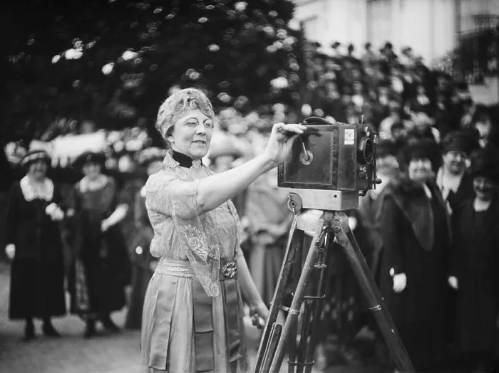 Framed Print : First Lady Florence Harding cranks a newsreel camera before a group of women journalists. Ca. 1921-23. (BSLOC_2015_15_68)