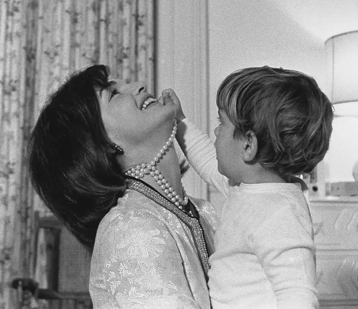 Framed Print : First Lady Jacqueline Kennedy laughs as her son John Kennedy Jr. plays with her simulated-pearl necklace in White House nursery. Nov. 27, 1962