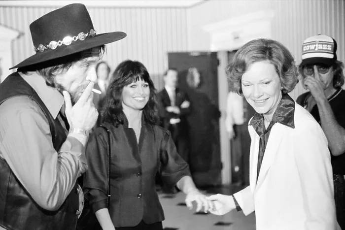 Framed Print : First Lady Rosalynn Carter with Waylon Jennings, smoking a cigarette, and Jesse Colter at a reception preceding a concert to benefit the Carter-Mondale campaign, April 23, 1980