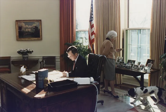 Framed Print : During his first week as president George Bush works in the Oval Office as wife Barbara looks at photographs behind the his desk. Jan. 27 1989. (BSLOC_2011_3_91) Framed Print : During his first week as president George Bush works in the Oval Office as wife Barbara looks at photographs behind the his desk. Jan. 27 1989. (BSLOC_2011_3_91)