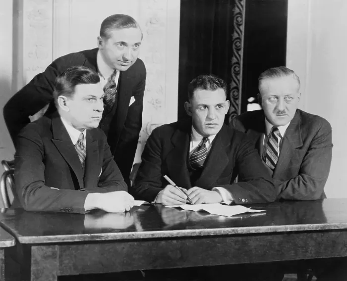 Framed Print : Football half-back, Harold E. Grange, signing a movie contract, at the Hotel Astor, ca. 1924. Depicted, L-R: W.E. Schallenberger, Pres. Of Arrow Pictures; Harry G