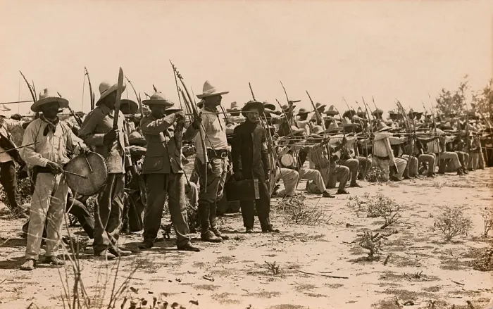 Framed Print : A formation of Mayo Indians with bows drawn during the Mexican Revolution, c. 1911-1914. At left a man beats a drum, while another raises a sword Framed Print : A formation of Mayo Indians with bows drawn during the Mexican Revolution, c. 1911-1914. At left a man beats a drum, while another raises a sword