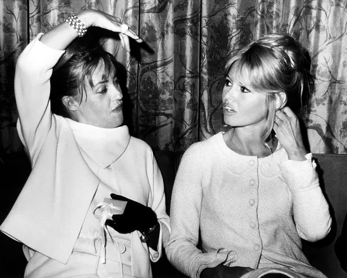 Framed Print : French actresses Jean Moreau (left) and Brigitte Bardot chat as they wait for a flight to Paris