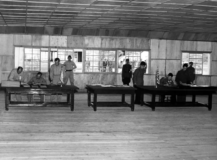 Framed Print : Gen. William Harrison, (left table) signs armistice ending the 3-year Korean conflict. At the right table, North Korean Gen. Nam II, signs documents. Panmunjom, July 23, 1953