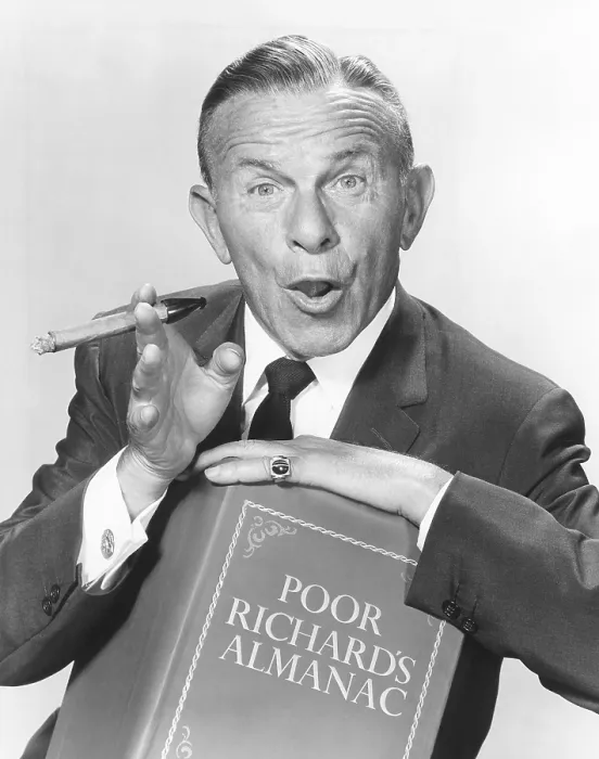 Framed Print : George Burns, holding a copy of Poor Richard's Almanac, circa 1950s