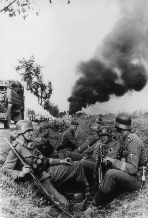Framed Print : German soldiers resting in a ditch on way to Pabjanice, during the invasion in Poland. In distance is a cloud of smoke from burning buildings. World War 2. Sept. 1939