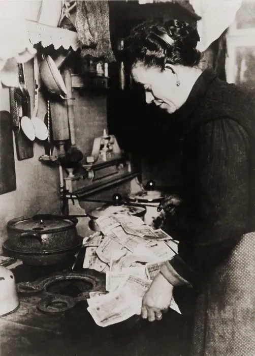 Framed Print : German women burning money to fuel her stove during the post World War I hyper-inflation in 1923. At the time, an American dollar was worth 800 million German marks Framed Print : German women burning money to fuel her stove during the post World War I hyper-inflation in 1923. At the time, an American dollar was worth 800 million German marks