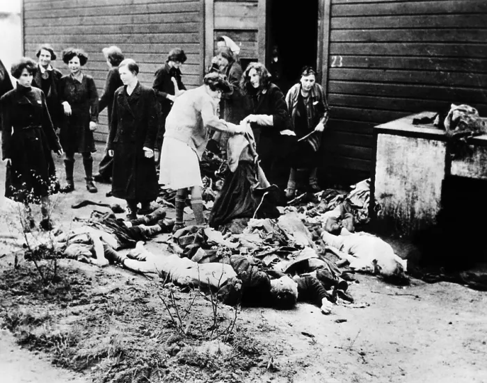 Framed Print : German women take clothes from the victims at Belsen concentration camp. Civilians were forced to view the atrocities after it was captured by the Allies, 1945