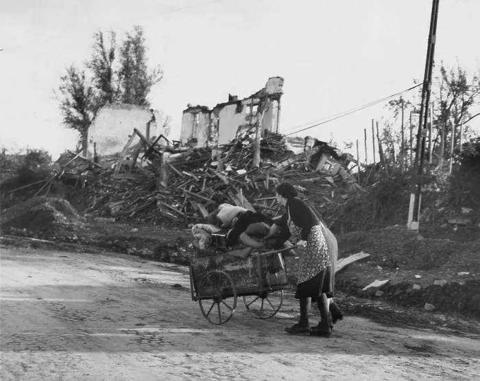 Framed Print : Two German women pushing their belongs in a cart past demolished buildings, Aachen, Germany