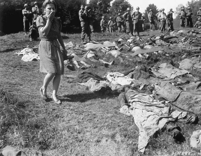 Framed Print : A German women walks past the exhumed bodies of some of the 800 slave workers. They were murdered by SS guards at Flossenburg concentration camp near Namering, Germany. U.S Framed Print : A German women walks past the exhumed bodies of some of the 800 slave workers. They were murdered by SS guards at Flossenburg concentration camp near Namering, Germany. U.S