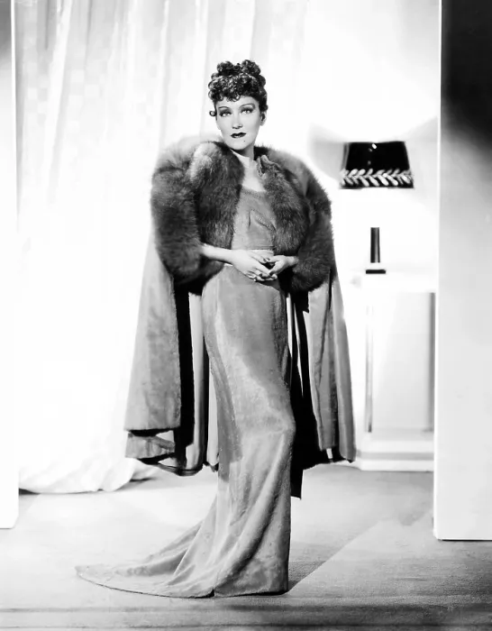 Framed Print : Gloria Swanson, modeling a rose-beige gown of clipped chiffon, with fox trim, ca. 1934