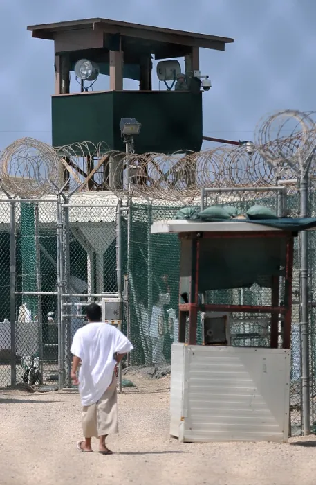 Framed Print : Under the guard tower a detainee walks in the recreation yard at Camp Delta the military prison for suspected Taliban and Al-Qaeda combatants at Guantanamo Bay Naval Base Cuba
