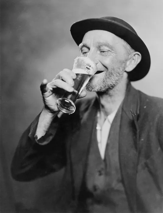 Framed Print : Happy old man drinking glass of beer, with his daintier finger extended. 1937