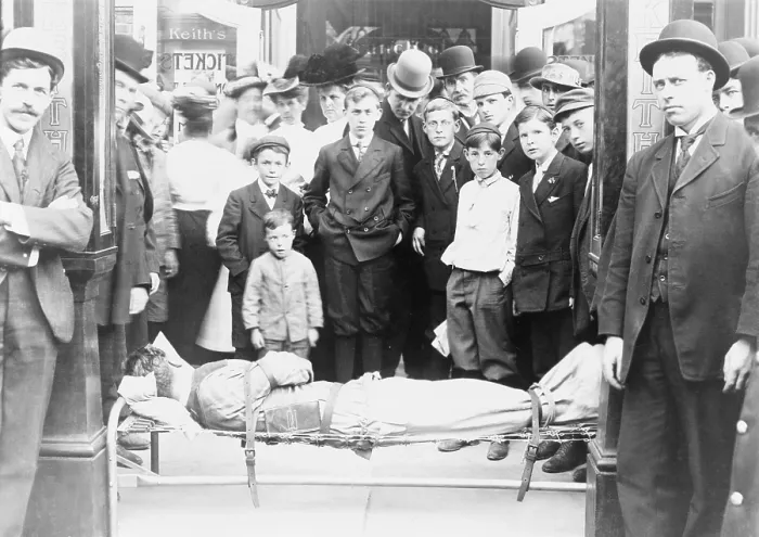 Framed Print : Harry Houdini (1874-1926), strapped to cot, with onlookers crowded around him in front of Keith's Theater, Boston, a major venue on the Vaudeville Circuit. Ca. 1910 Framed Print : Harry Houdini (1874-1926), strapped to cot, with onlookers crowded around him in front of Keith's Theater, Boston, a major venue on the Vaudeville Circuit. Ca. 1910