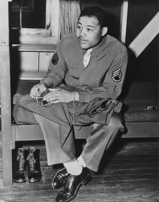 Framed Print : Heavyweight champion Joe Louis sews on the stripes of a technical sergeant