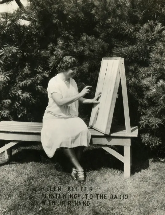 Framed Print : Helen Keller listening to the radio with her hand