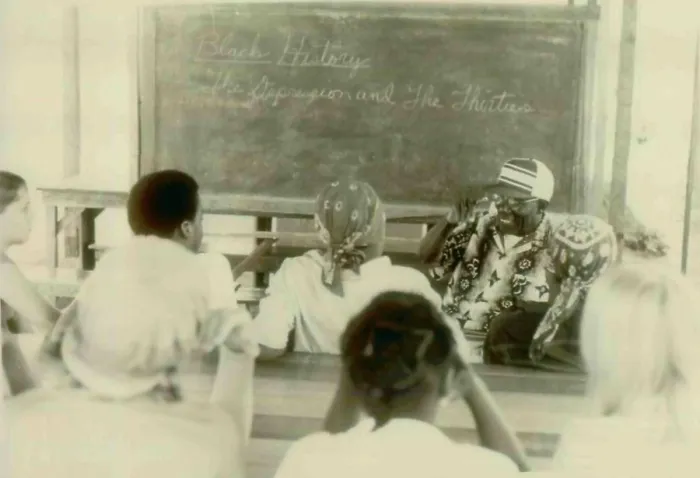 Framed Print : Henry Mercer teaching school. Written on the blackboard is Black History. The Depression and the Thirties. The People's Temple Agricultural Project Framed Print : Henry Mercer teaching school. Written on the blackboard is Black History. The Depression and the Thirties. The People's Temple Agricultural Project