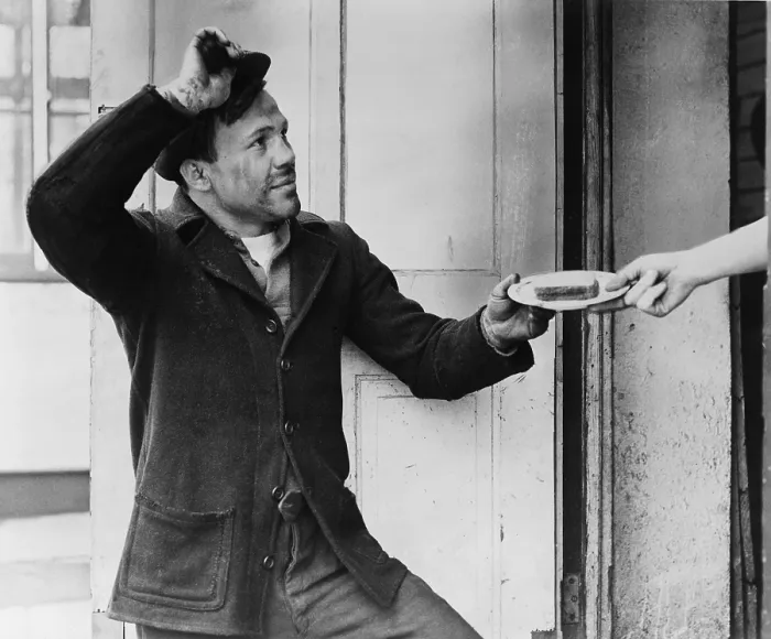 Framed Print : A Hobo, Lou Ambers, tips his hat as he accepts a sandwich from a woman's hand during the Great Depression