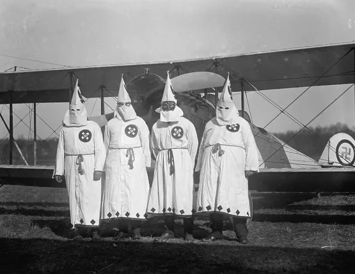 Framed Print : Four hooded Ku Klux Klan members pose in from of their airplane which bears a swastika emblem. 1922 photo