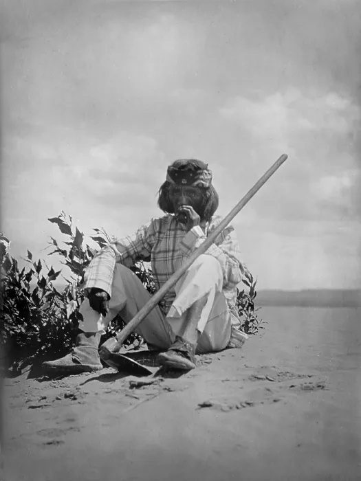 Framed Print : Hopi man sitting on ground smoking, with hoe propped on his left knee, original title: A quiet smoke Hopi, photograph by Edward S. Curtis, 1907