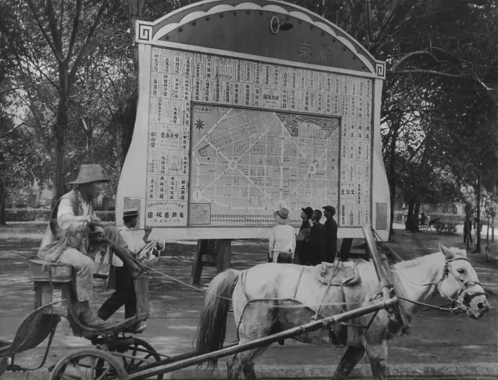 Framed Print : Horse drawn wagon passes billboard with Japanese plan for new city of Hsinking, Manchukuo