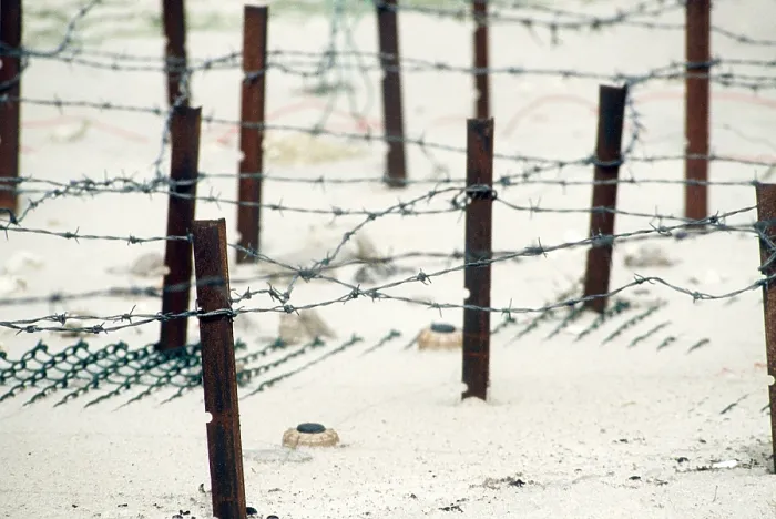 Framed Print : Iraqi anti-personnel mines and barbed wire fences line a beach prior to being cleared in the aftermath of Operation Desert Storm. 1991. (BSLOC_2011_12_27)