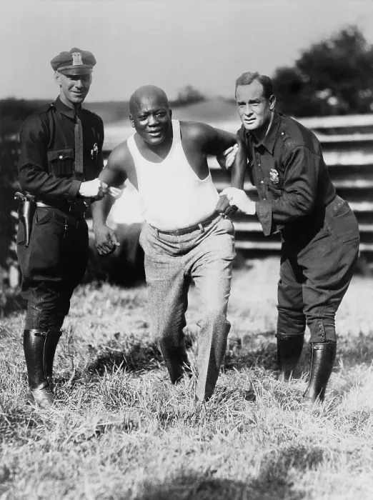 Framed Print : Jack Johnson, being held by two police officers in mock restraint, after being caught speeding in Orangeburgh, Pennsylvania, in 1929 (BSLOC_2020_2_185) Framed Print : Jack Johnson, being held by two police officers in mock restraint, after being caught speeding in Orangeburgh, Pennsylvania, in 1929 (BSLOC_2020_2_185)