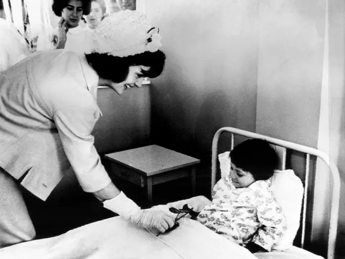 Framed Print : Jacqueline Kennedy (left), presents a patient at the children's hospital with a flower in Bogota, Colombia. December 17, 1961. Courtesy: CSU Archives / Everett Collection