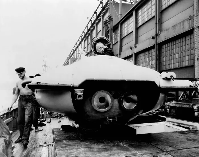 Framed Print : Jacques Cousteau, peering out a two-man underwater observation chamber on board the Calypso as it docks in New York City for the International Oceanographic Congress