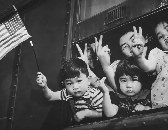 Framed Print : Japanese-American children waving from a train window as it leaves Seattle to take them to an internment camp for the duration of World War II. March 1942