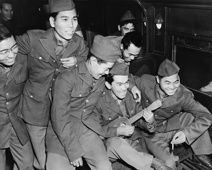 Framed Print : Japanese American soldiers enjoy the music of a Hawaiian ukulele as they wait to detrain at Camp Shelby, Mississippi in 1943