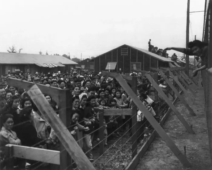 Framed Print : Japanese Americans behind barbed wire fence waving to friends leaving Santa Anita Camp on a train