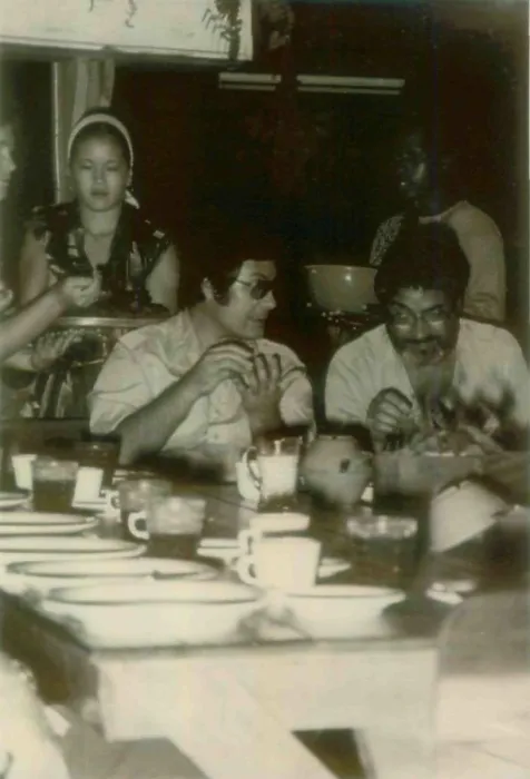 Framed Print : Jim Jones and a guest in Jonestown. At left is Kim Tschetter serving dinner. People's Temple Agricultural Project. Jonestown, Guyana. Nov. 1978