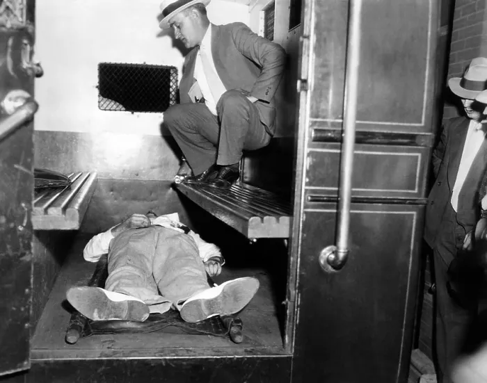 Framed Print : John Dillinger, dead with toes up in a police patrol wagon, is taken from the scene of his killing by FBI agents in Chicago. July 22, 1934