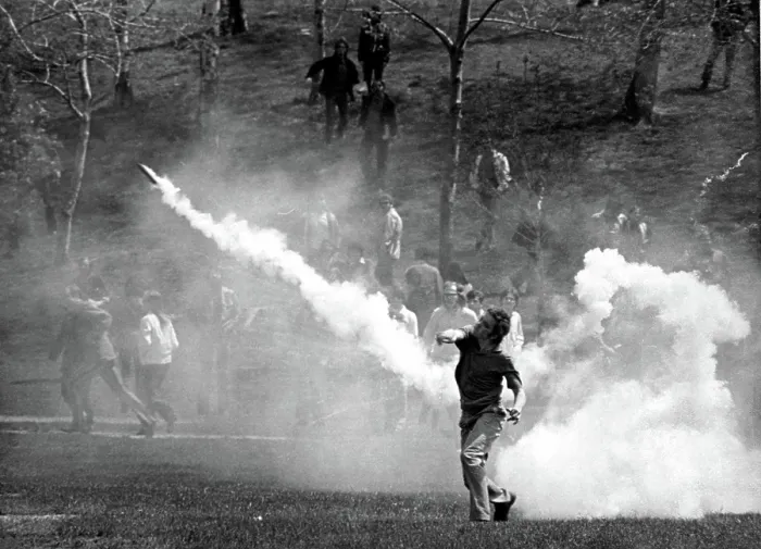 Framed Print : KENT STATE UNIVERSITY, student tosses a tear-gas bomb back at the National Guard who fired it to disperse the crowd. Kent, Ohion 5 / 4 / 70