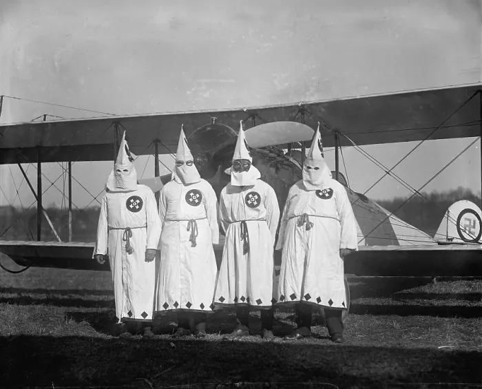 Framed Print : The Ku Klux Klan, one with flight goggles, in front of airplane, swastika adorns plane rear, March 18, 1922