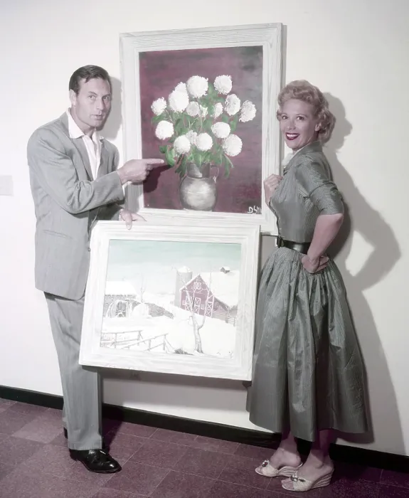 Framed Print : From left: George Montgomery, Dinah Shore (his wife), posing with some of the paintings that she made, circa 1950s Framed Print : From left: George Montgomery, Dinah Shore (his wife), posing with some of the paintings that she made, circa 1950s