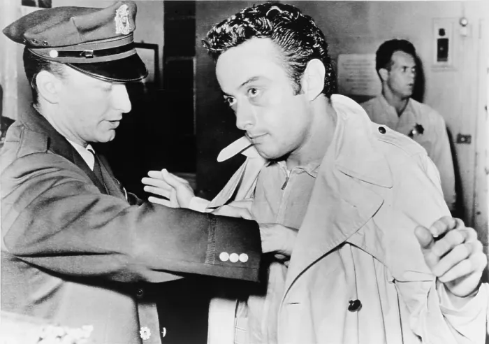 Framed Print : Lenny Bruce (1925-1966), being searched at police station after his October 4, 1961 arrest for using obscene language during his standup act at the Jazz Workshop in San Francisco