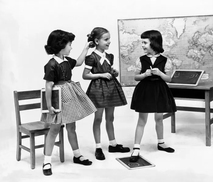 Framed Print : Little girls school dressed in 1953. They echo the Dior's New Look with their full gathered skirts and belted waists, worn with crisp white ankle socks