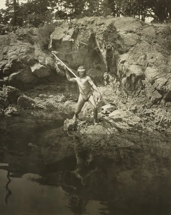 Framed Print : Lummi man aiming his spear at a salmon in the Puget Sound area. 1924 photo by Fred H. Kiser