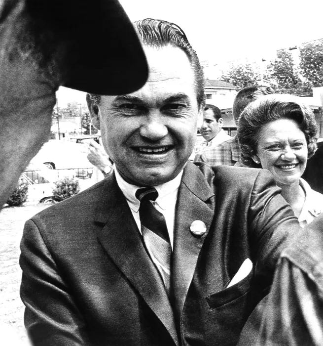 Framed Print : Lurleen Wallace a surrogate candidate for her husband, stays in the background as her husband, Governor George Wallace, shakes hands with voters in Clayton, Alabama. May 3, 1966