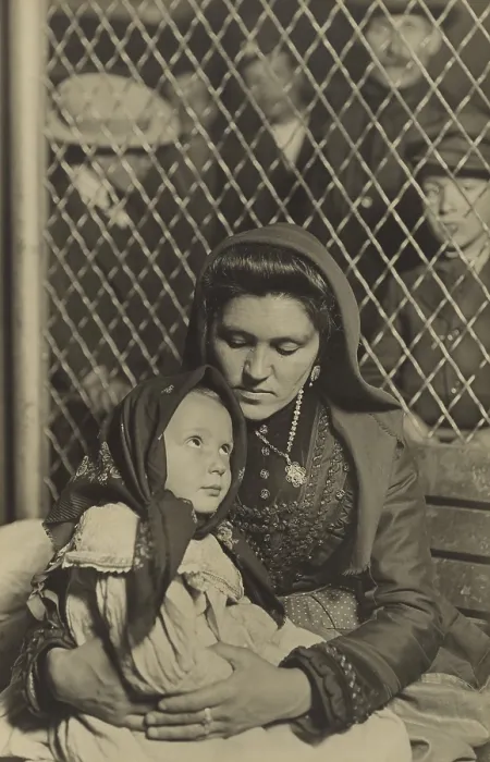 Framed Print : MADONNA AND CHILD, ELLIS ISLAND, 1908, by Lewis Hine. An Italian mother and daughter on a bench separated by a wire partition from a group of men