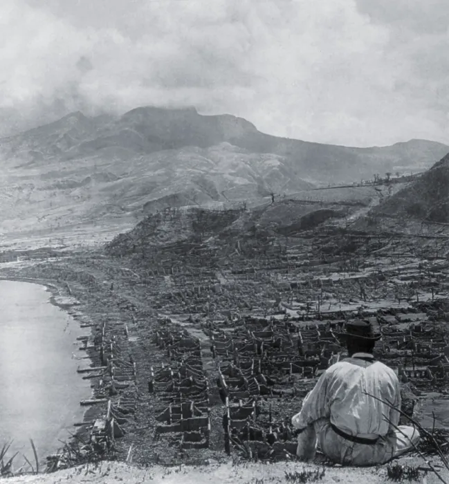Framed Print : Man on Orange Hill looks over the dead city of St. Pierre, and up to steaming volcano, Mont Pelee. A pyroclastic flow killed 30, 000 people in the coastal city on June 8, 1902