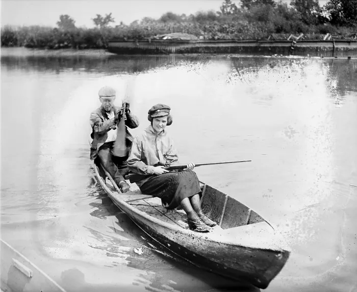 Framed Print : Man and woman in a canoe, the woman holds a gun, 1921