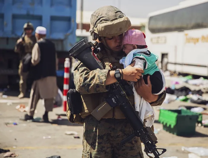 Framed Print : A US Marine holds a baby while its family is cleared for during the non-combatant evacuation operation at Kabul, Afghanistan, Aug. 28, 2021 (BSLOC_2021_14_43)