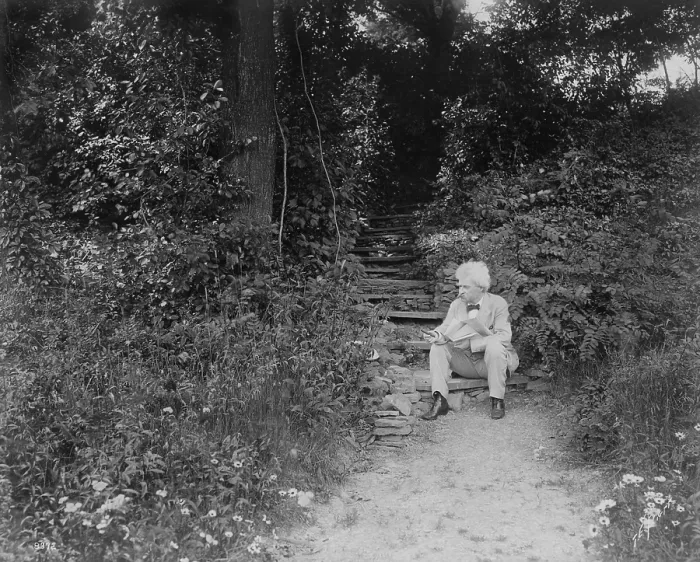 Framed Print : Mark Twain (aka Samuel Clemens), seated on step, outdoors, holding cigar, a book, and newspaper, 1903. Photo by T.E. Marr (BSLOC_2016_11_135)