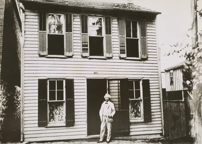 Framed Print : Mark Twain (aka Samuel Clemens), in front of his boyhood home in Hannibal, Missouri, c. 1900. The great American writer was born Samuel Langhorne Clemens in 1835 Framed Print : Mark Twain (aka Samuel Clemens), in front of his boyhood home in Hannibal, Missouri, c. 1900. The great American writer was born Samuel Langhorne Clemens in 1835
