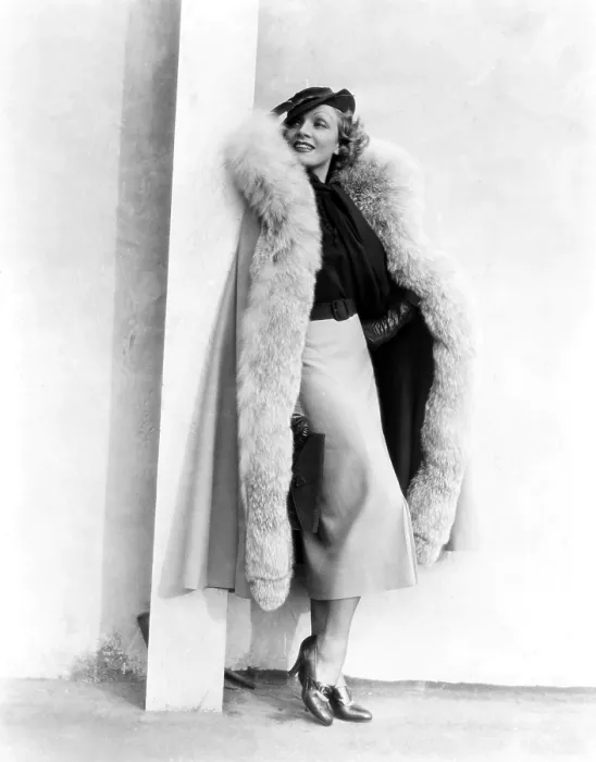 Framed Print : Marlene Dietrich, in a brown and beige suit and lynx-trimmed beige wool cape by Travis Banton, 1935